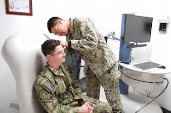 260510-N-FT324-8502. ROTA, Spain (May 10, 2026)-- Hospital Corpsman 3rd Class Martin E. Romero Alvarez, a native of Dalton, Georgia, assigned to Navy Medicine Readiness and Training Command Rota, demonstrates a physical ear examination on a Sailor using a telehealth medical cart inside the Telehealth Clinic. Romero Alvarez works in telemedicine, supporting remote patient care and enabling virtual medical consultations to ensure timely, high-quality healthcare for Sailors and Marines across the region. (U.S. Navy photo by Lt. Cmdr. Alicia Sacks)