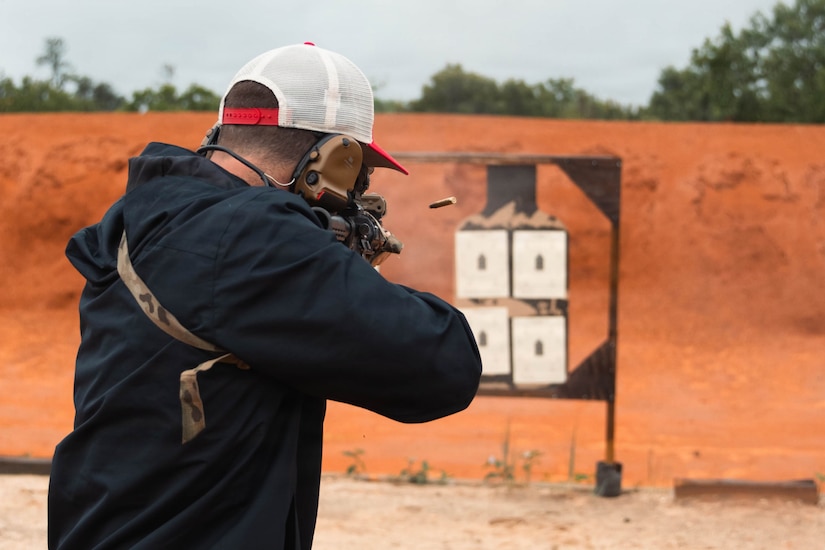 A man shoots a weapon at a target.
