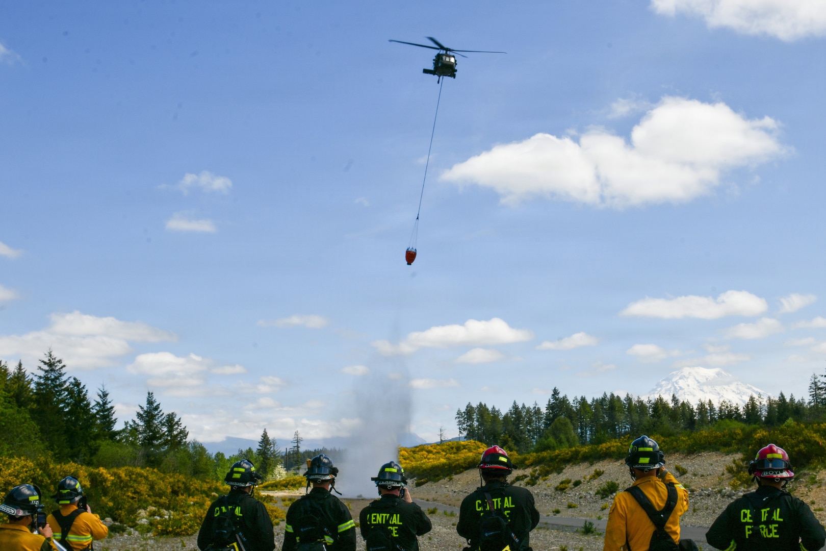 A UH-60 Black Hawk helicopter assigned to 1st Battalion, 168th General Support Aviation Battalion, Washington Army National Guard conducts a water bucket drop during wildfire response training with Central Pierce Fire and Rescue near Puyallup, Washington, May 7, 2026.
