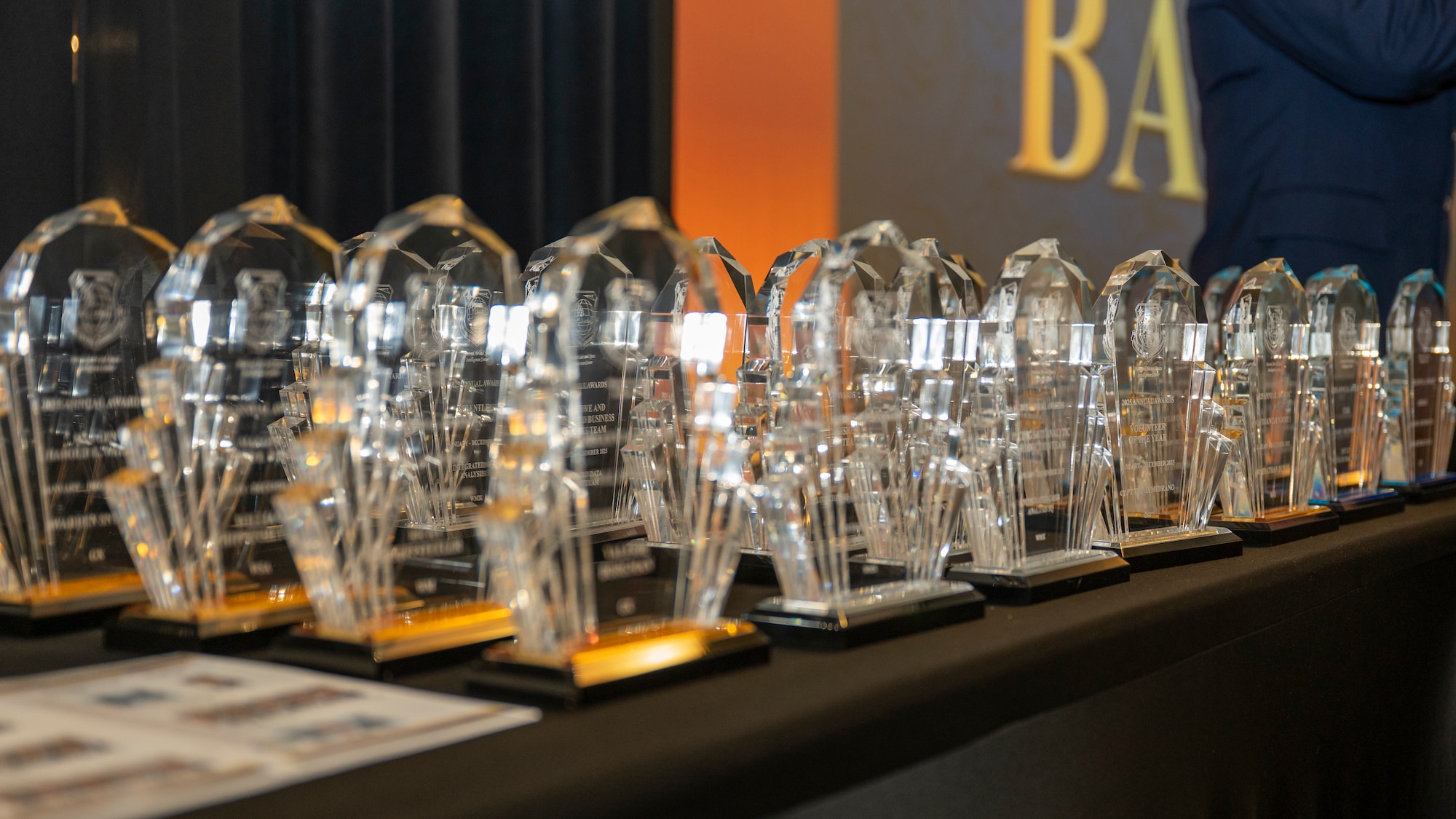 Annual awards and specialty trophies sit on a display table prior to the 2025 National Air and Space Intelligence Center Annual Awards Ball.