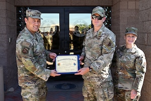 U.S. Airmen holding a certificate.