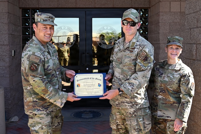 U.S. Airmen holding a certificate.