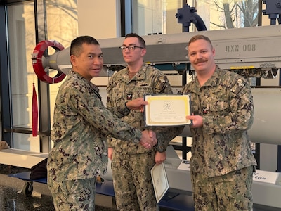 AT2 Weaver receives the Military Outstanding Volunteer Service Medal (MOVSM) from NSWC Crane Commanding Officer, CAPT Rex Boonyobhas.