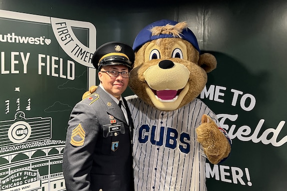 Sgt. 1st Class Moises Garcia, 85th U.S. Army Reserve Support Command, meets Clark, the Chicago Cubs’ mascot, after a military recognition during a Chicago Cubs MLB home game verses the Cincinnati Reds, May 5, 2026, at Wrigley Field.