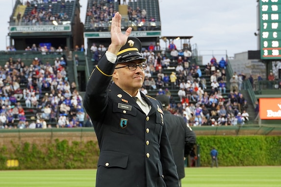 Sgt. 1st Class Moises Garcia, 85th U.S. Army Reserve Support Command, waves to a crowd of cheering fans during the Chicago Cubs military salute recognition, May 5, 2026, at Wrigley Field. Garcia was honored for his 31 years of service, including five overseas deployments.