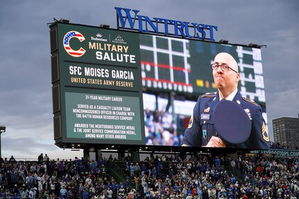 Sgt. 1st Class Moises Garcia, 85th U.S. Army Reserve Support Command, appears on the Wrigley Field jumbotron during a military salute at the Chicago Cubs home game, May 5, 2026, at Wrigley Field. Garcia was honored for his 31 years of service, including five overseas deployments.