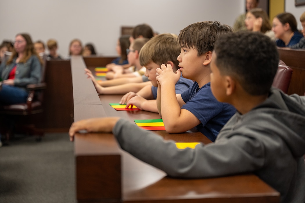 Students from Mendel L. Rivers Elementary School observe a mock trial at Altus Air Force Base, Oklahoma, May 1, 2026. Students used verdict cards to participate in the trial and learn about courtroom procedures during a Law Day event hosted by the 97th Air Mobility Wing Judge Advocate office. (U.S. Air Force photo by Airman 1st Class Nathan Langston)