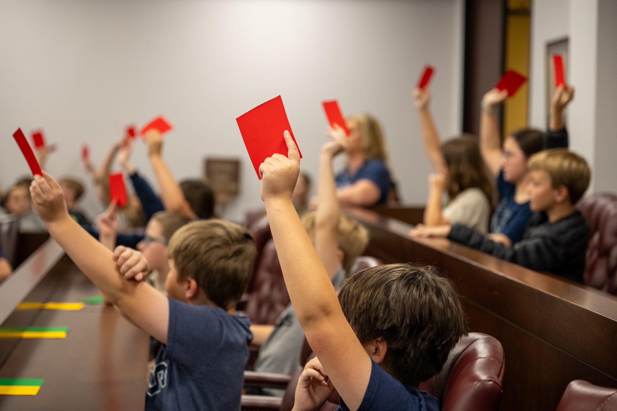 Students from Mendel L. Rivers Elementary School hold up cards to render their verdict during a mock trial at Altus Air Force Base, Oklahoma, May 1, 2026. The activity gave students a hands-on look at courtroom procedures and the legal process as part of a Law Day event hosted by the 97th Air Mobility Wing Judge Advocate office. (U.S. Air Force photo by Airman 1st Class Nathan Langston)