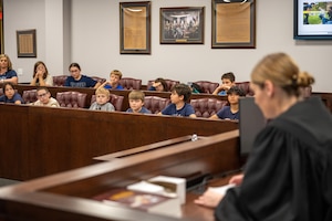 U.S. Air Force Capt. Samantha Hullibeger, 97th Air Mobility Wing military justice chief, leads a mock trial at Altus Air Force Base, Oklahoma, May 1, 2026. The mock trial gave local fourth-grade students a hands-on look at courtroom procedures and the legal process as part of a Law Day event hosted by the 97th AMW Judge Advocate office. (U.S. Air Force photo by Airman 1st Class Nathan Langston)