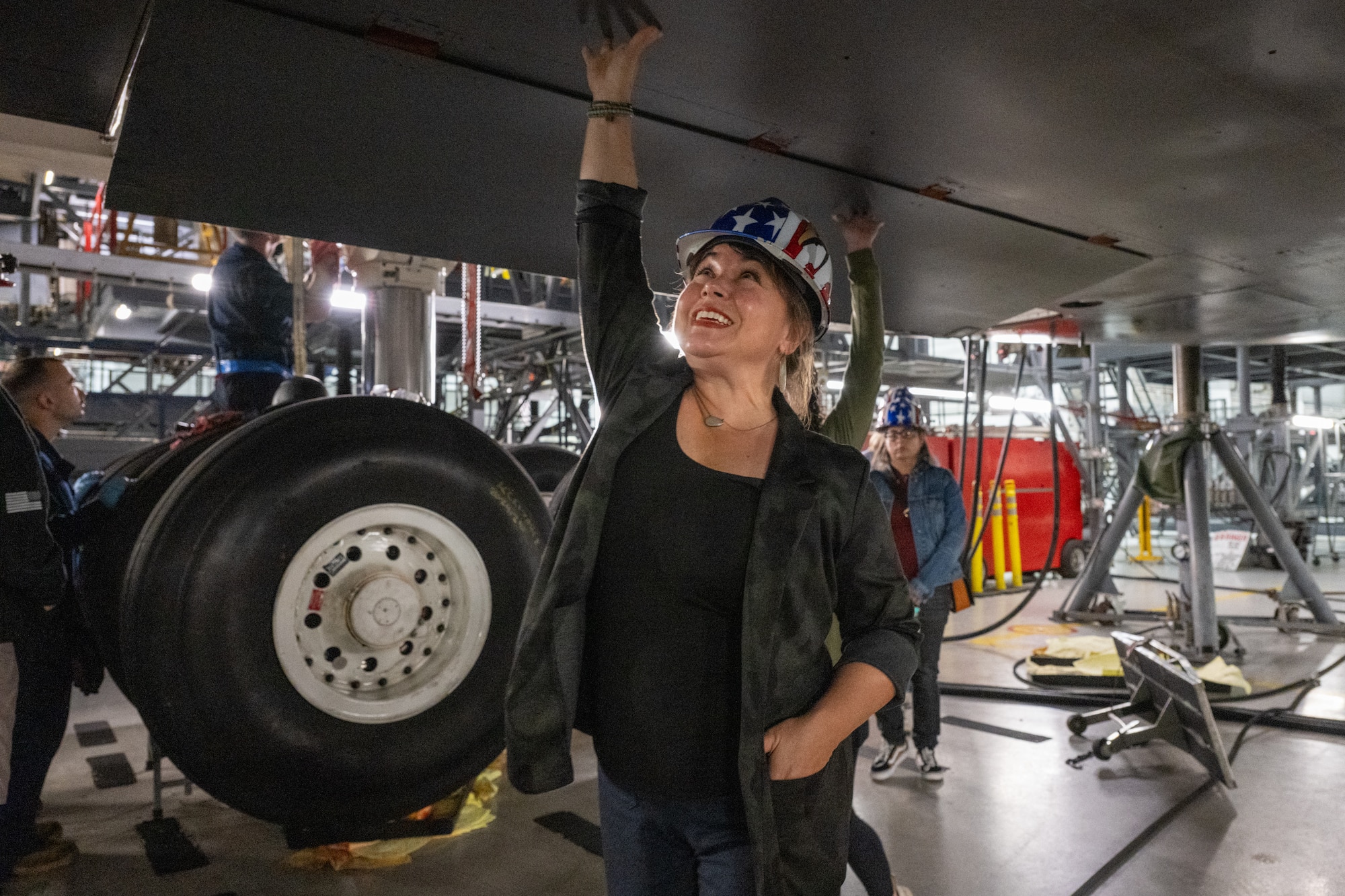 DeDe Musa, spouse of U.S. Air Force Col. Jamil Musa, 436th Airlift Wing commander, touches the underside of a C-5M Super Galaxy while touring the isochronal inspection dock at Dover Air Force Base, Delaware, May 5, 2026. The tour, in observance of Military Spouse Appreciation Day, offered an up-close look at how the 436th AW projects power and delivers hope through rapid global mobility. (U.S. Air Force photo by Mauricio Campino)