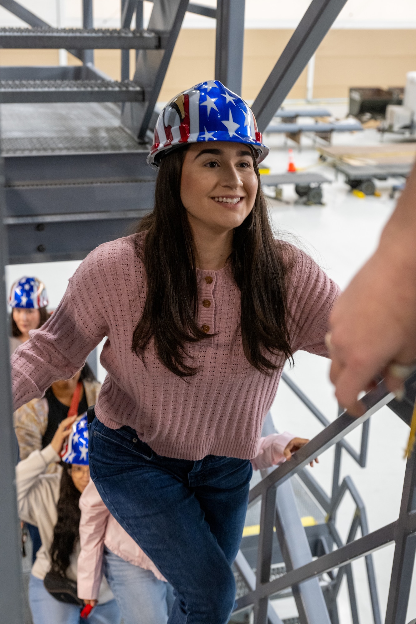 Military spouses climb maintenance platforms while touring the isochronal inspection dock at Dover Air Force Base, Delaware, May 5, 2026. The tour, in observance of Military Spouse Appreciation Day, helped familiarize the spouses with the mission of the 436th Airlift Wing and aspects unique to Dover AFB. (U.S. Air Force photo by Mauricio Campino)