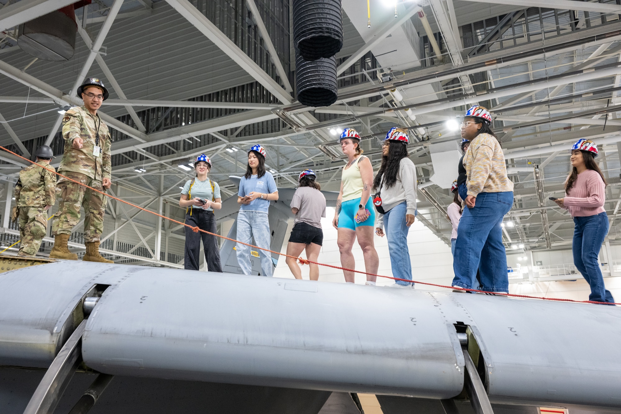 Military spouses walk on the wing of a C-5M Super Galaxy while touring the isochronal inspection dock at Dover Air Force Base, Delaware, May 5, 2026. The tour, in observance of Military Spouse Appreciation Day, also made stops at the air traffic control tower and the Delaware United Service Organization. (U.S. Air Force photo by Mauricio Campino)