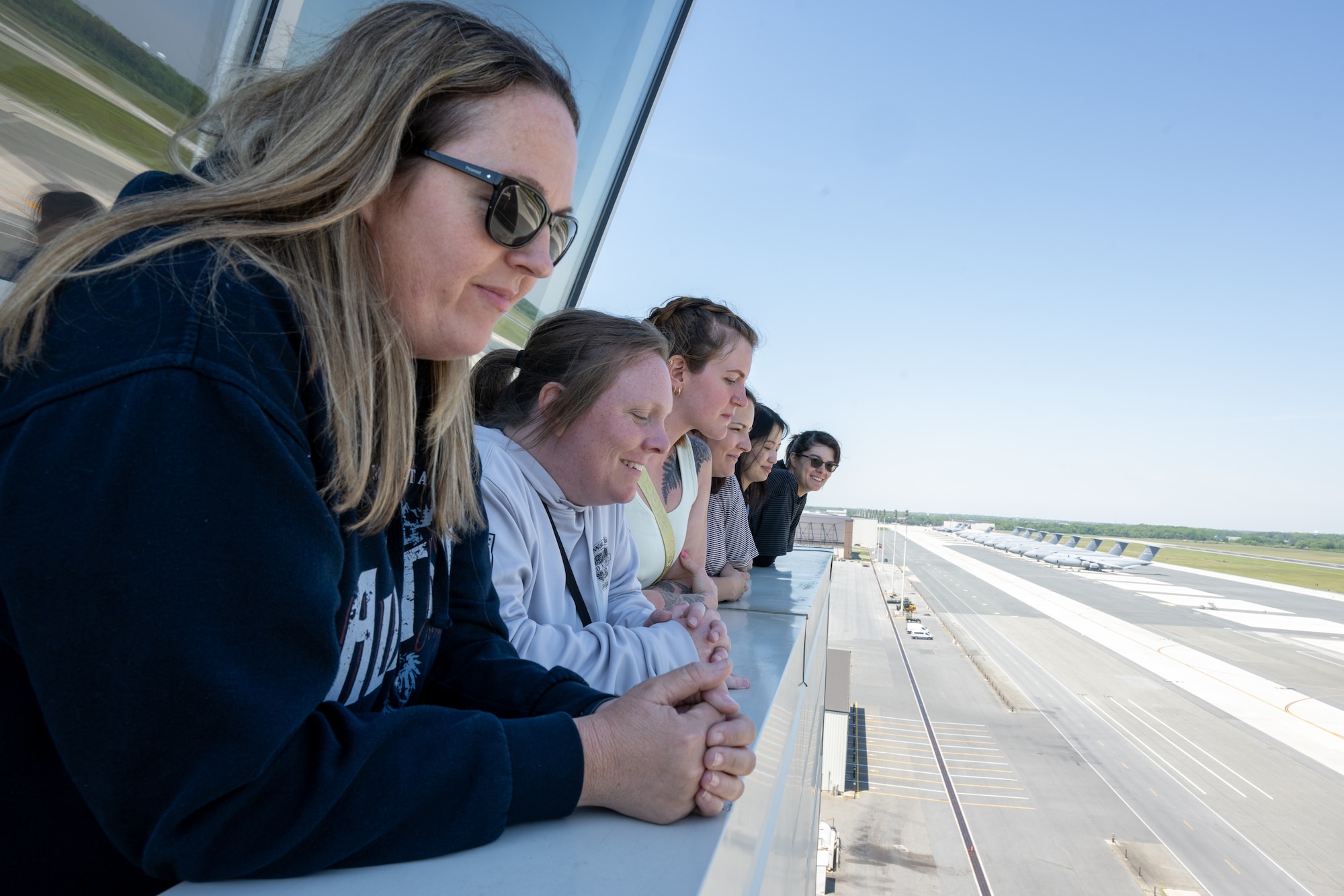 Military spouses look over the flightline from atop the air traffic control tower at Dover Air Force Base, Delaware, May 5, 2026. The tour, in observance of Military Spouse Appreciation Day, offered a behind-the-scenes perspective of daily life at Dover AFB. (U.S. Air Force photo by Mauricio Campino)