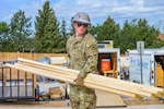 Interior electrician Spc. Derrick Dawson, assigned to Wyoming Army National Guard’s 307th Engineer Utilities Detachment, carries wooden planks during a two-week Innovative Readiness Training project providing military engineer training while helping construct homes for local residents in Cheyenne, Wyoming, May 9, 2026. Partnered with Habitat for Humanity, the project is part of the Department of War Innovative Readiness Training program, which allows military units to support community organizations while conducting mission-essential engineer training. Photo by Sgt. 1st Class Cesar Rivas.