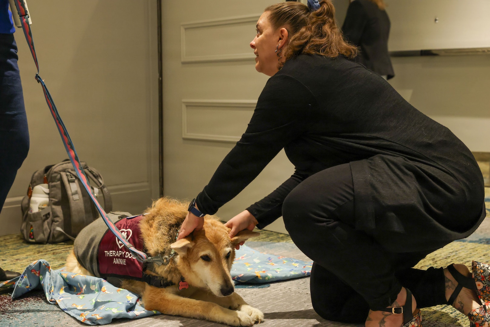A family member pets Annie, from Love on a Leash, a therapy dog organization that provides certified therapy dogs for veterans and others in need, during the Defense POW/MIA Accounting Agency Family Member Update in Detroit, Mi., May 2, 2026.