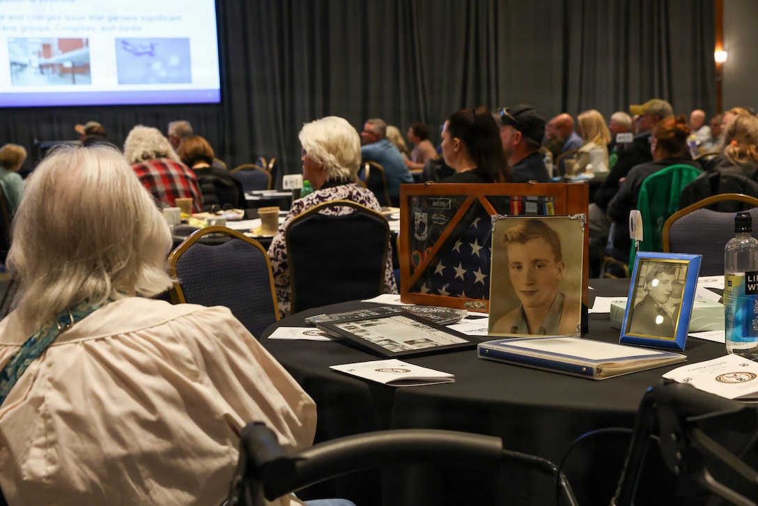 A family member displays photos of their loved one during the DPAA Family Member Update in Detroit, Mi., May 2, 2026.