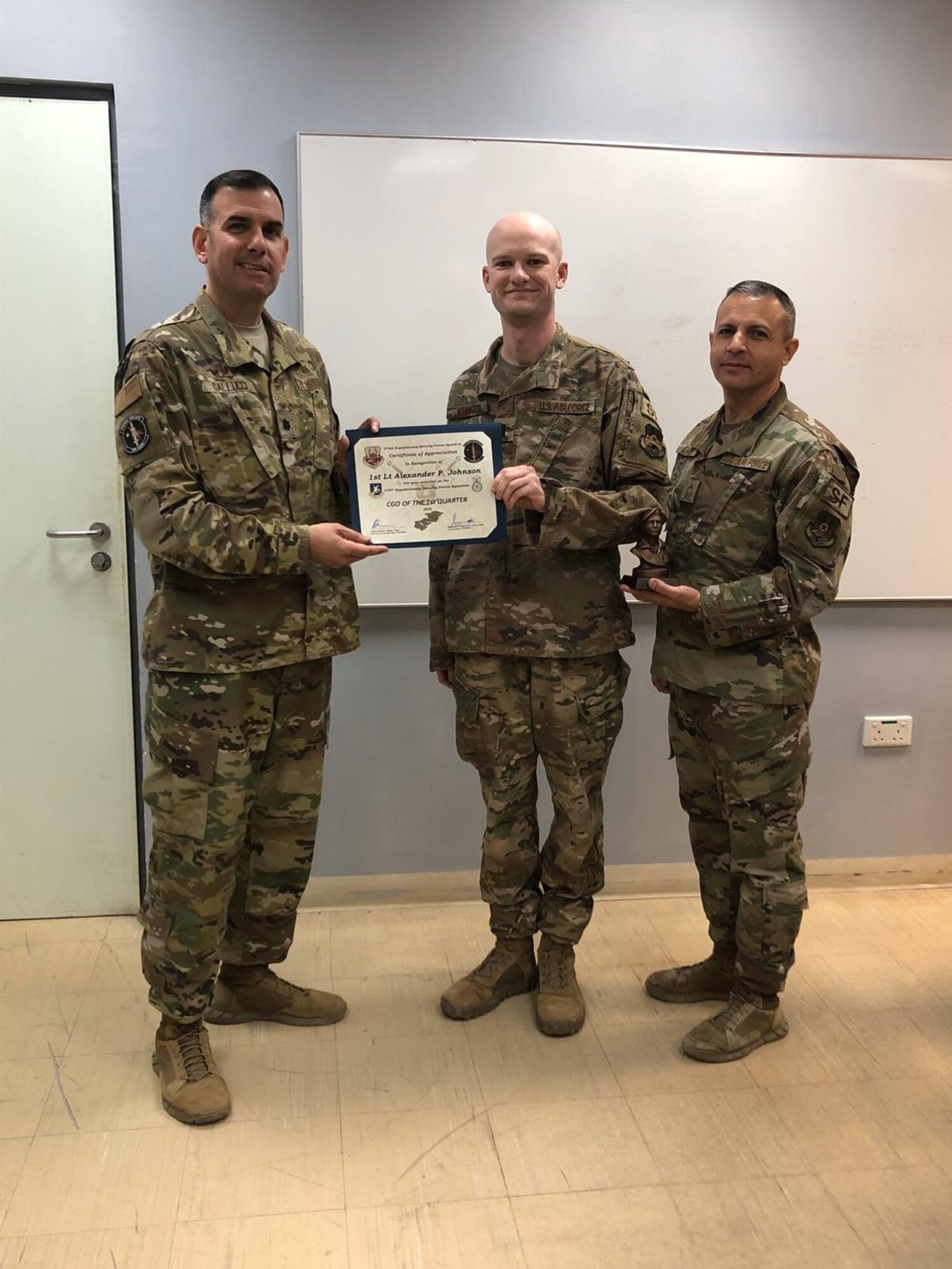 From left, Lt. Col. Mike Gallucci, 379th Expeditionary Security Forces Squadron commander, 1st Lt. Alexander Johnson, 379th Expeditionary SFS officer, and Chief Master Sgt. Alex Angulo, 379th Expeditionary SFS chief, pose for a photo in March 2020 as Johnson is awarded Company Grade Officer of the Quarter. The moment was pivotal in Johnson’s career as he began discussing his mental health with his leadership team. (Courtesy photo)
