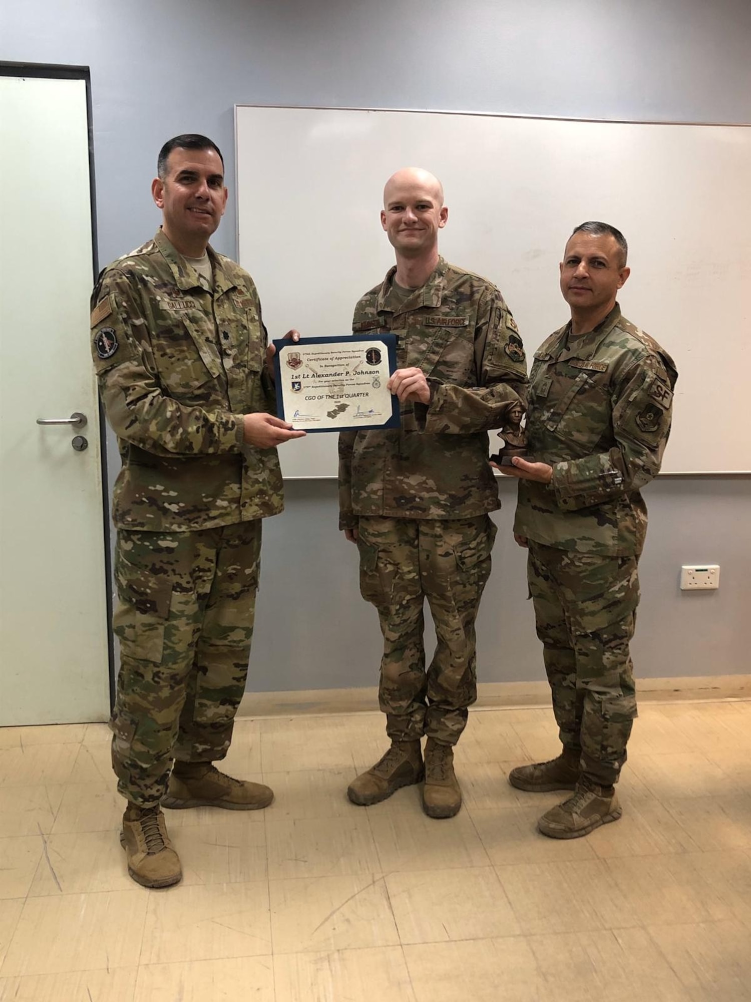 From left, Lt. Col. Mike Gallucci, 379th Expeditionary Security Forces Squadron commander, 1st Lt. Alexander Johnson, 379th Expeditionary SFS officer, and Chief Master Sgt. Alex Angulo, 379th Expeditionary SFS chief, pose for a photo in March 2020 as Johnson is awarded Company Grade Officer of the Quarter. The moment was pivotal in Johnson’s career as he began discussing his mental health with his leadership team. (Courtesy photo)