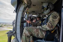 U.S. Air Force Brig. Gen. John Gallemore, left, 18th Wing commander, briefs Gen. Kevin Schneider, Pacific Air Forces commander, during an HH-60W Jolly Green Il flight over Kadena Air Base, Japan, April 29, 2026. The engagement highlighted the wing's role in maintaining readiness across the Indo-Pacific. (U.S. Air Force photo by Senior Airman Melany Bermudez)