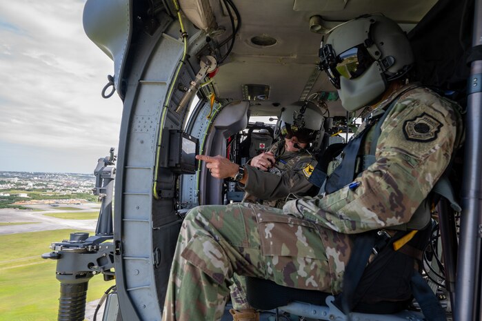 U.S. Air Force Brig. Gen. John Gallemore, left, 18th Wing commander, briefs Gen. Kevin Schneider, Pacific Air Forces commander, during an HH-60W Jolly Green Il flight over Kadena Air Base, Japan, April 29, 2026. The engagement highlighted the wing's role in maintaining readiness across the Indo-Pacific. (U.S. Air Force photo by Senior Airman Melany Bermudez)