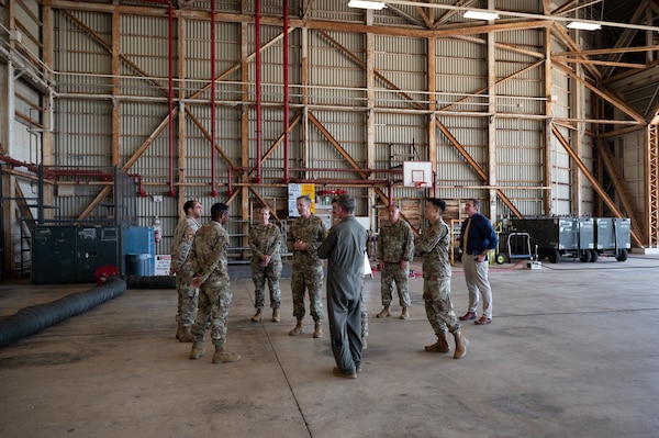 U.S. Air Force Gen. Kevin Schneider, left, Pacific Air Forces commander, and Brig. Gen. John Gallemore, right, 18th Wing commander, engage with Airmen during an immersion tour at Kadena Air Base, Japan, April 29, 2026. The visit provided insight into how Airmen across the wing integrate capabilities to sustain combat power in the Indo-Pacific. (U.S. Air Force photo by Airman 1st Class Karina Lopez)