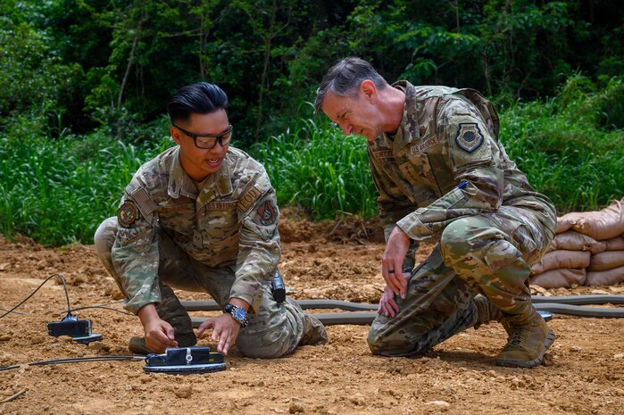 U.S. Air Force Gen. Kevin Schneider, right, Pacific Air Forces commander, observes Senior Airman Jack Reynard, 18th Civil Engineer Squadron explosive ordnance disposal journeyman, explain controlled detonation procedures at Kadena Air Base, Japan, April 29, 2026. The demonstration highlighted EOD capabilities supporting installation safety and mission effectiveness. (U.S. Air Force photo by Airman 1st Class Francisco Huerta)