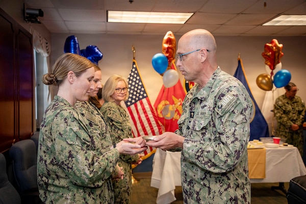 260511-N-KC192-2006 PORTSMOUTH, Va. (May 11, 2026) Lt. Cmdr. Erica Monsees, assigned to Navy and Marine Corps Force Health Protection Command (NMCFHPC), has her hands blessed by Capt. David Jeltma, Naval Medical Forces Atlantic (NMFL) Chaplain,, during a blessing of the hands ceremony held during National Nurses Week involved in the aftermath of combat, chaplains use practices like the Blessing of the Hands to strengthen their spiritual resilience. It represents their shared obligation to prepare the force for the emotional and ethical demands of military medicine. Nurses from NMFL, Defense Health Agency (DHA), and NMCFHPC participated together, highlighting the unity and joint effort across Navy Medicine and the Military Health System in support of operational readiness. (U.S. Navy photo by Mass Communication Specialist Second Class Levi Decker)