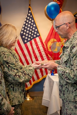 260511-N-KC192-2010 PORTSMOUTH, Va. (May 11, 2026) Rear Adm. Kimberly Sandberg, reserve deputy director, Naval Medical Forces Atlantic (NMFL), has her hands blessed by Capt. David Jeltma, Naval Medical Forces Atlantic Chaplain, during a Blessing of the Hands ceremony held during National Nurses Week onboard Naval Support Activity (NSA) Hampton Roads - Portsmouth Annex, May 11, 2026. Recognizing that medical personnel are often involved in the aftermath of combat, chaplains use practices like the Blessing of the Hands to strengthen spiritual resilience and reinforce the emotional and ethical readiness required in military medicine. The ceremony also highlighted the unity of active duty, reserve, Defense Health Agency (DHA), and Navy and Marine Corps Force Health Protection Command (NMCFHPC) nursing professionals in support of operational readiness. (U.S. Navy photo by Mass Communication Specialist Second Class Levi Decker)