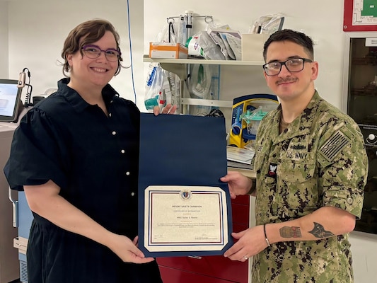 260425-O-LY941-1944
GUANTANAMO BAY, Cuba - Hospital Corpsman 2nd Class Taylor Keene, assigned to U.S. Navy Medicine Readiness and Training Command, Guantanamo Bay, receives a Patient Safety Champion Certificate of Recognition at the hospital from Patient Safety Manager, Kathleen Kauffman, April 24, 2026. Keene, who works at U.S. Naval Hospital Guantanamo Bay, was recognized for going above and beyond in support of the patient safety mission by identifying and implementing new safety initiatives and serving as a TeamSTEPPS trainer, exemplifying Ready Reliable Care in action. (U.S. Navy courtesy photo)