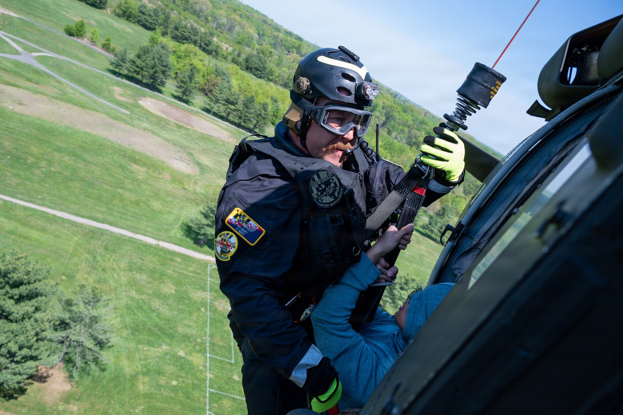 A technician from the Maryland Helicopter Aquatic Response Team and a member of the Maryland Air National Guard Student Flight are hoisted into a Maryland Army National Guard UH-60 Black Hawk during a Maryland Emergency Management Search and Rescue Exercise at Gunpowder Falls State Park, Maryland, April 23, 2026. State agencies, local jurisdictions, and non-governmental organizations gathered in Baltimore County to test their skills through a series of immersive scenarios during the 12-hour operational period. (U.S. Air National Guard Photo by Senior Airman Sarah Hoover)