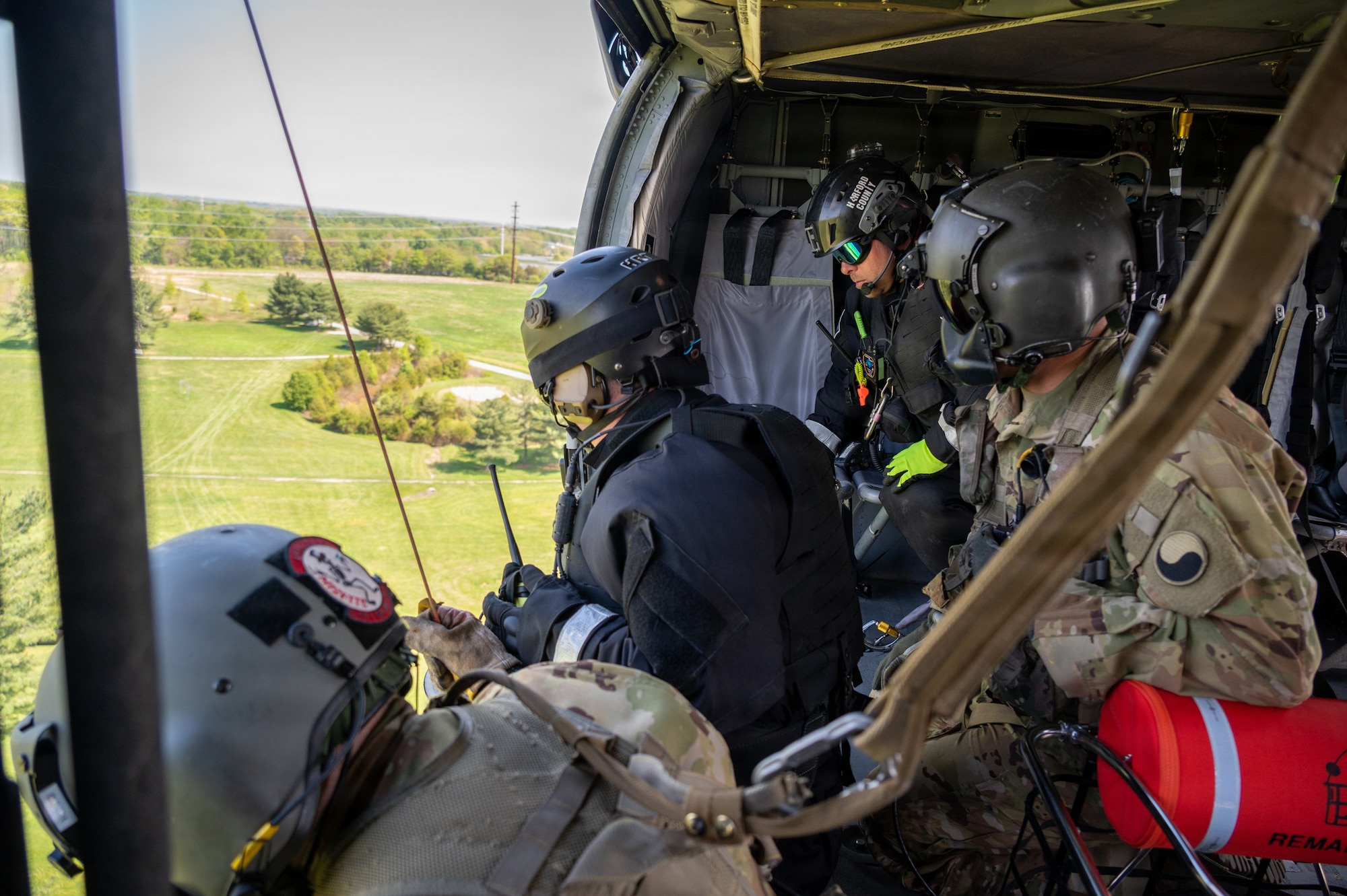 Two technicians from the Maryland Helicopter Aquatic Response Team and two members of the Maryland Army National Guard 29th Combat Aviation Brigade conduct a simulated hoist rescue out of a UH-60 Black Hawk during a Maryland Emergency Management Search and Rescue Exercise at Gunpowder Falls State Park, Maryland, April 23, 2026. State agencies, local jurisdictions, and non-governmental organizations gathered in Baltimore County to test their skills through a series of immersive scenarios during the 12-hour operational period. (U.S. Air National Guard Photo by Senior Airman Sarah Hoover)