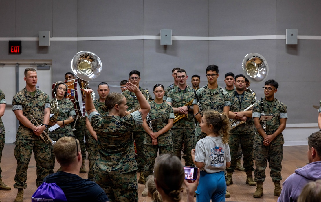 U.S. Marine Corps Gunnery Sgt. Lindsey Waller, center, an ensemble leader and ceremonial conductor with the 2nd Marine Division Band, teaches a young girl how to conduct during a homeschooler community event on Marine Corps Base Camp Lejeune, North Carolina, April 30, 2026. The 2nd MARDIV band hosted homeschoolers from the Onslow County area, taking them on tours, teaching them about production and the various instruments the band utilizes. (U.S. Marine Corps photo by Cpl. Noelia Vazquez)