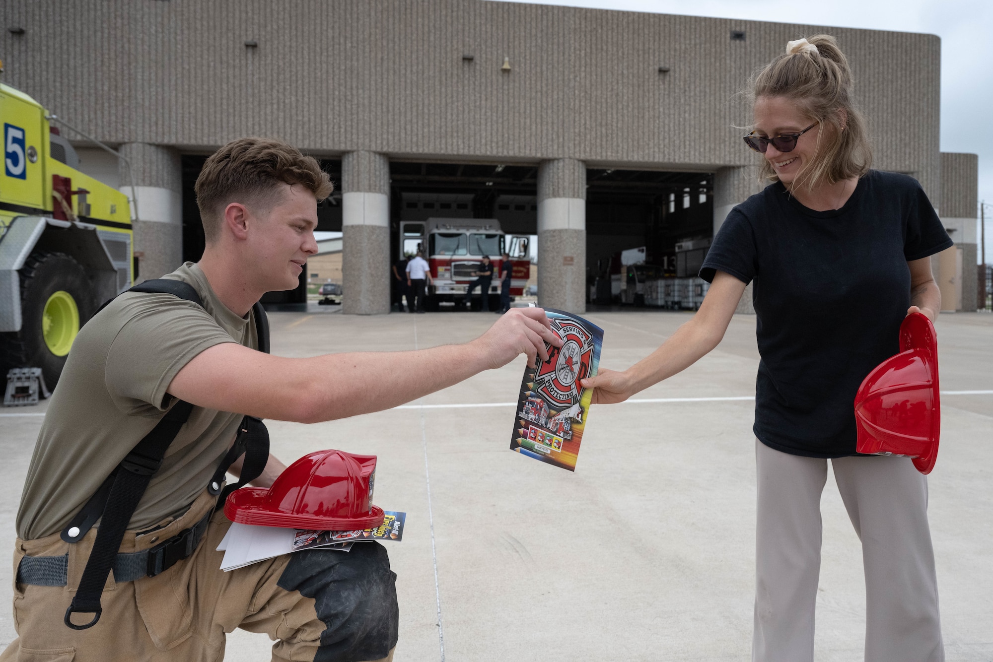 U.S. Air Force Airman 1st Class Connor Barry, 47th Civil Engineer Squadron firefighter, hands out souvenirs to a military spouse during Military Spouse Appreciation Day at Laughlin Air Force Base, Texas, May 8, 2026. The 47th CES educated military spouse and families about their daily operations and equipment. (U.S. Air Force photo by Airman 1st Class Darryl Keith)