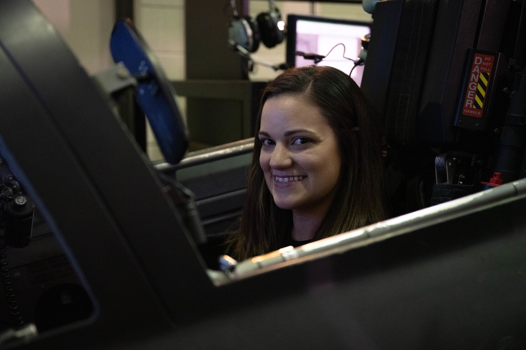 A military spouse poses while sitting inside a T-38C Talon simulator during Military Spouse Appreciation Day at Laughlin Air Force Base, Texas, May 8, 2026. Military spouses and family members experienced T-6A Texan II and T-38 simulators to learn more about Undergraduate Pilot Training. (U.S. Air Force photo by Airman 1st Class Darryl Keith)