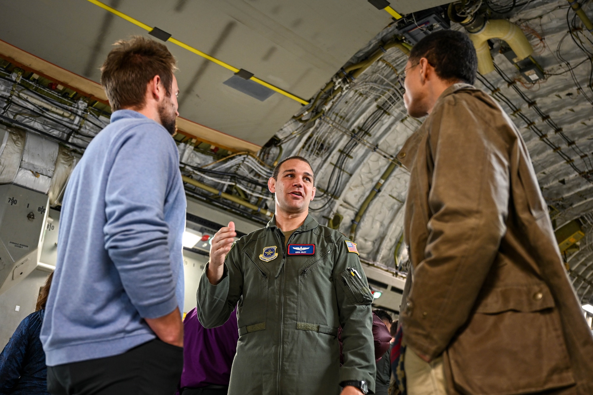 A man speaking to two others.