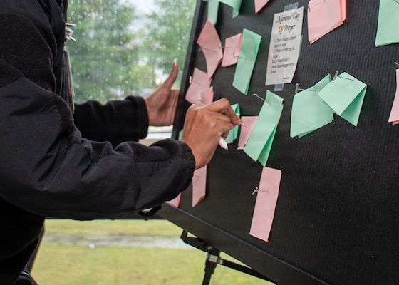 PORTSMOUTH, Va. (May 8, 2026) A Sailor assigned to Naval Medical Center Portsmouth (NMCP) places a prayer on a prayer board during National Day of Prayer at NMCP, May 8, 2026. Navy Medicine Readiness and Training Command (NMRTC) Portsmouth is the premier readiness and training platform that provides superior medical training for military medical service members at NMCP, the U.S. military’s oldest, continuously operating military hospital since 1830. (U.S. Navy photo by Mass Communication Specialist 2nd Class Thomas Boatright)
