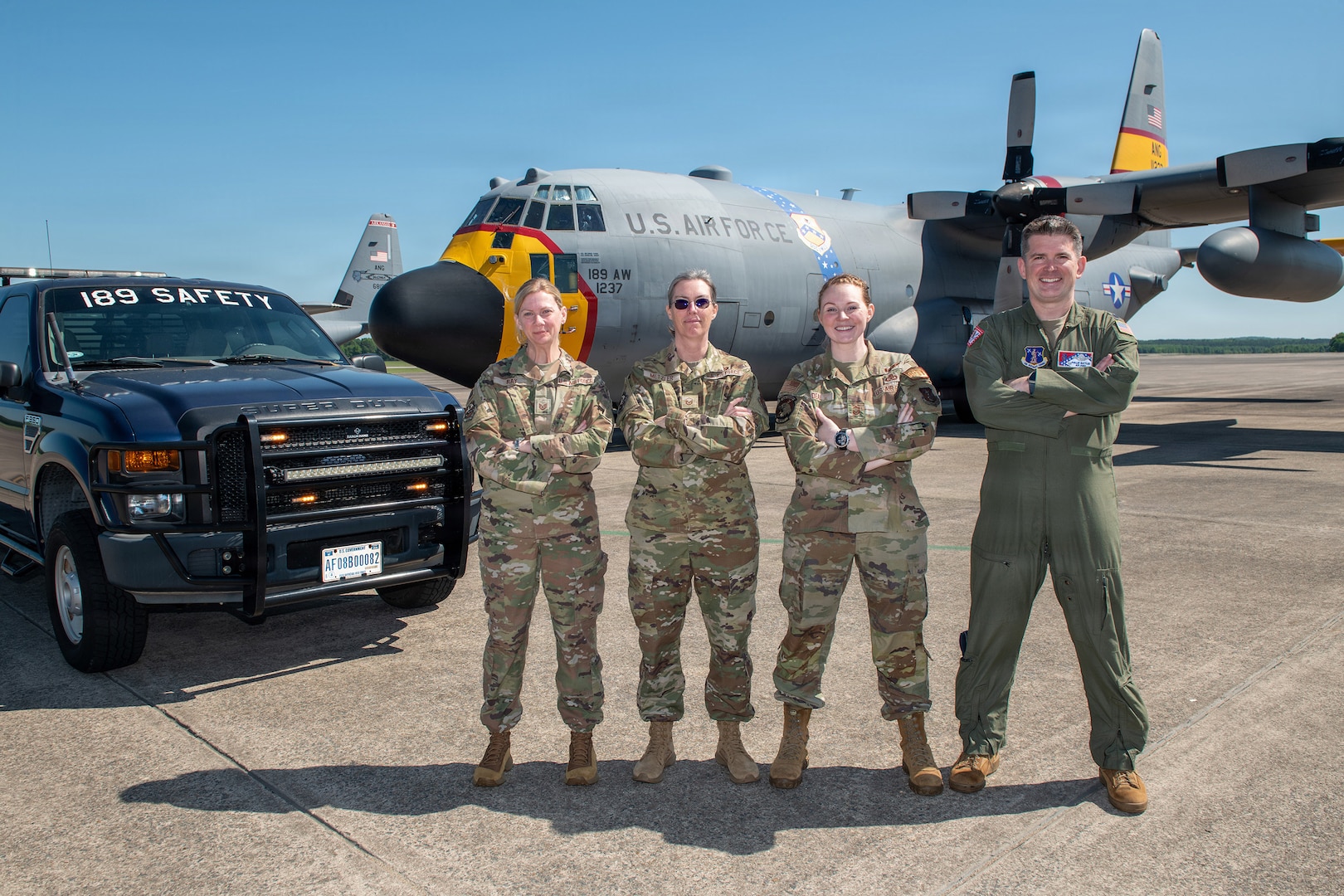 From left to right, U.S. Air Force Tech. Sgt. Martha Ray, safety technician; Master Sgt. Heather Metzler, safety technician; Senior Master Sgt. Jessica Deal, occupational safety manager; and Lt. Col. Phillip Battles, chief of safety, 189th Airlift Wing safety team, pose in front of a C-130H and safety truck at Little Rock Air Force Base, Arkansas, May 3, 2026.