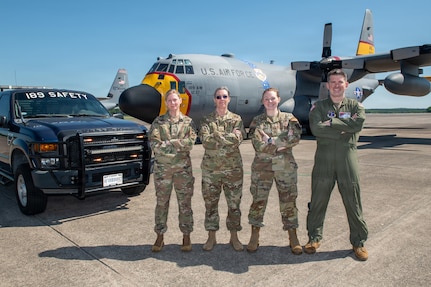 From left to right, U.S. Air Force Tech. Sgt. Martha Ray, safety technician; Master Sgt. Heather Metzler, safety technician; Senior Master Sgt. Jessica Deal, occupational safety manager; and Lt. Col. Phillip Battles, chief of safety, 189th Airlift Wing safety team, pose in front of a C-130H and safety truck at Little Rock Air Force Base, Arkansas, May 3, 2026.