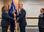 Maj. Daniel M. McFadden (right) receives the 74th Aerial Port Squadron guidon from Lt. Col. Cindy  Storoy (left), 433rd Mission Support Group commander, as he assumes command of the 74th APS during a change of command ceremony in San Antonio, Texas, May 2, 2026. McFadden brings operational and logistics experience to the role, leading a unit that enables global mobility missions. (U.S. Air Force photo by Senior Airman Joshua Fontenot)