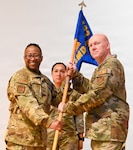 Col. Alvin Bradford, 433rd Medical Group interim commander, presents the 433rd Aerospace Medicine Squadron guidon to Col. Stephen Taylor, 433rd AMDS commander, during an assumption of command ceremony at Joint Base San Antonio-Lackland, Texas, April 12, 2026. The assumption of command ceremony is a military tradition that represents a formal transfer of authority and responsibility for a unit. (U.S. Air Force photo by Master Sgt. Jacob Lewis)