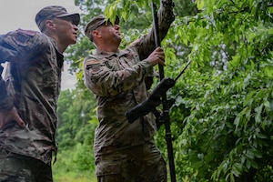 U.S. Air Force Col. Jun S. Oh, 316th Wing and installation commander and Chief Master Sgt. Kevin W. Helms, 316 Wing command chief, learn how to use a R12 during a “Winnin’ Like a Griffin”