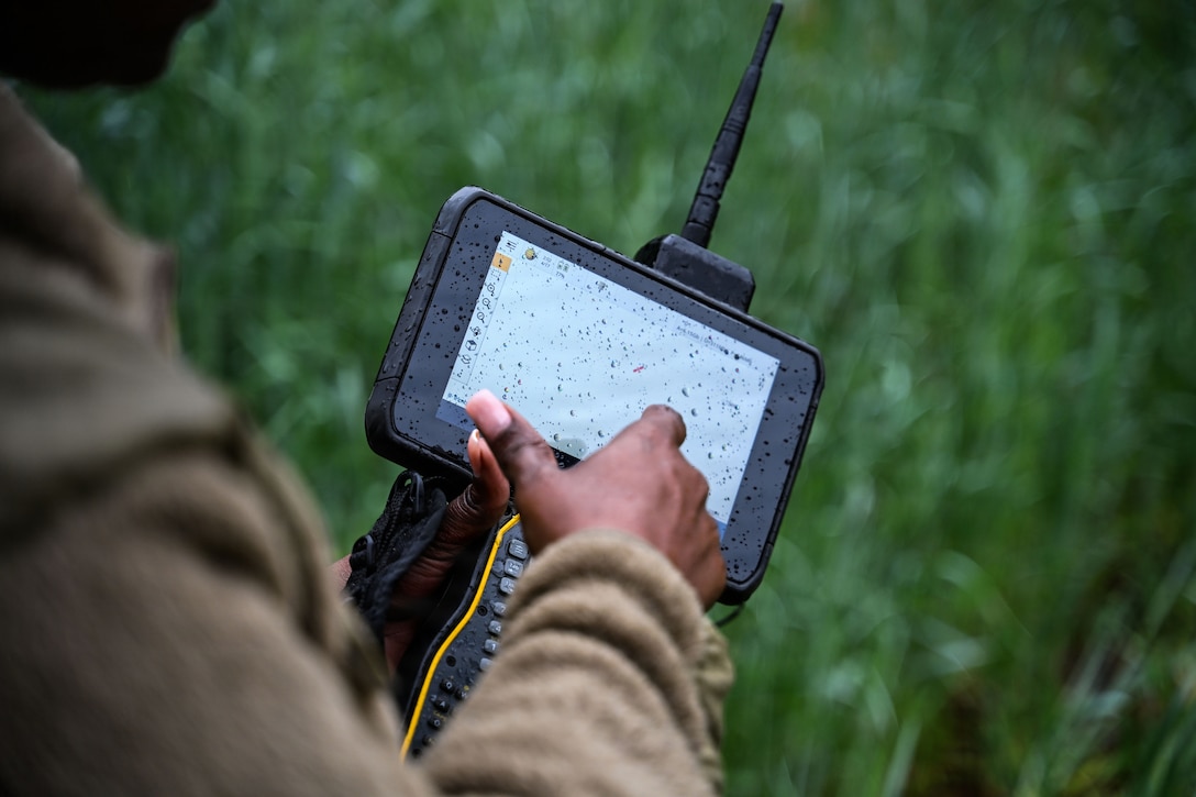 U.S. Air Force Senior Airman Sashakay T. Christie, an engineering assistant supervisor assigned to the 316th Civil Engineer Squadron, demonstrates surveying techniques during a “Winnin’ Like a Griffin”