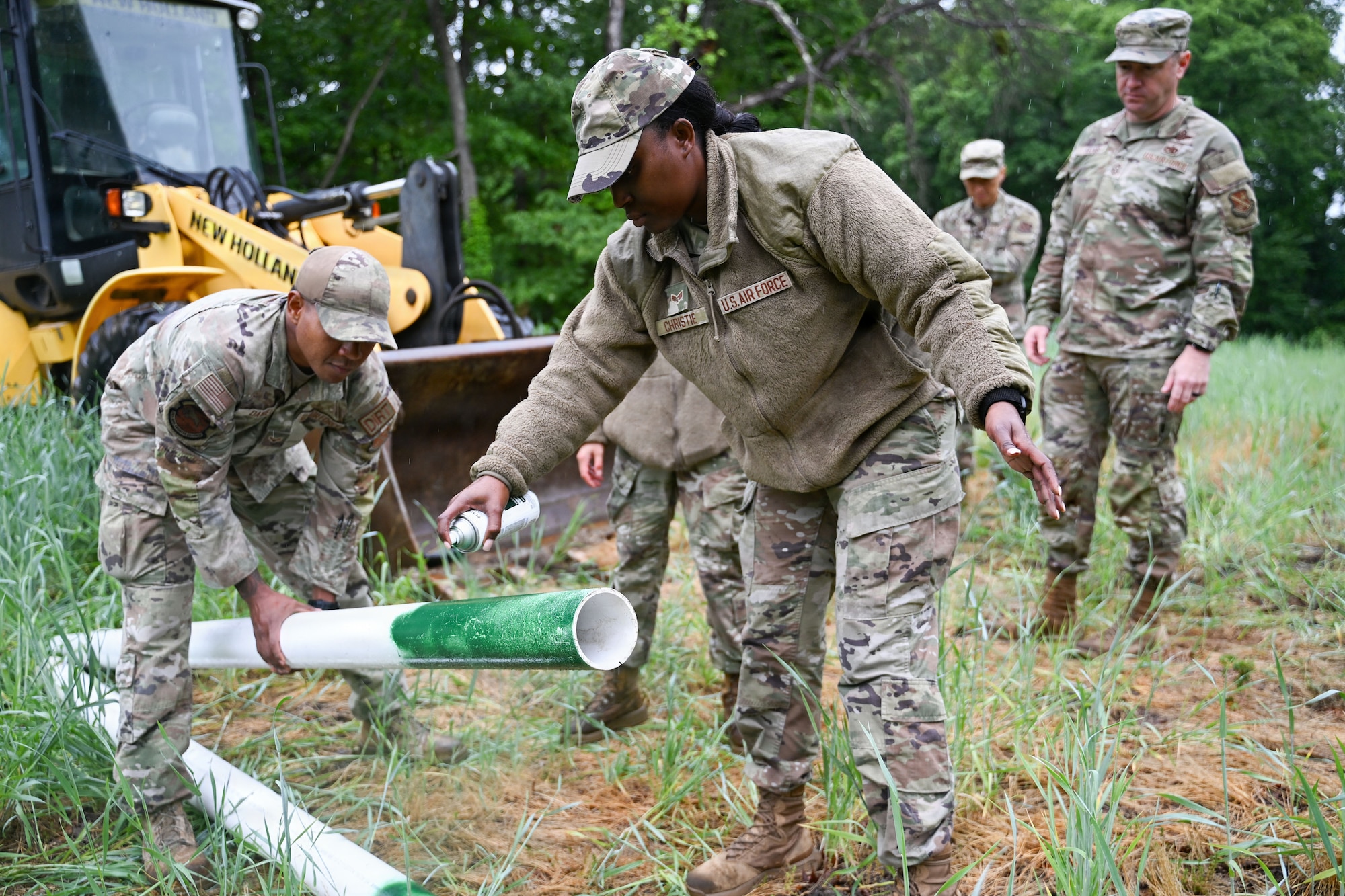 U.S. Air Force Senior Airman Sashakay T. Christie, an engineering assistant supervisor assigned to the 316th Civil Engineer Squadron, spray paints a coordinate marker during a “Winnin’ Like a Griffin”