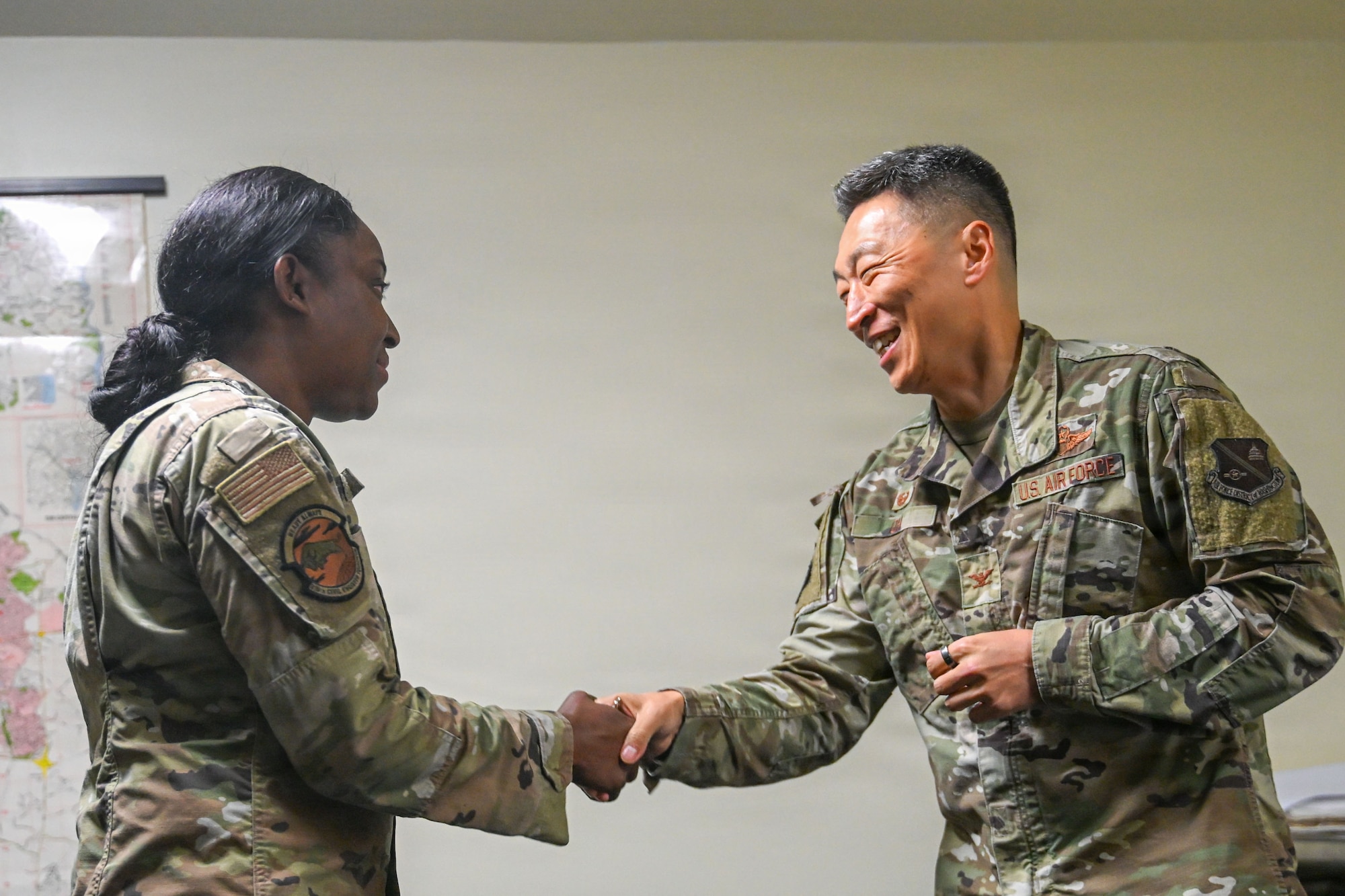 U.S. Air Force Col. Jun S. Oh, 316th Wing and installation commander, presents a commander’s coin to Senior Airman Sashakay T. Christie