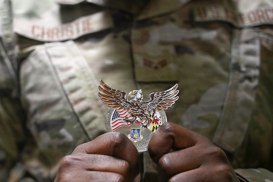 U.S. Air Force Senior Airman Sashakay T. Christe, an engineering assistant supervisor assigned to the 316th Civil Engineer Squadron, displays a commander's coin during a “Winnin’ Like a Griffin”