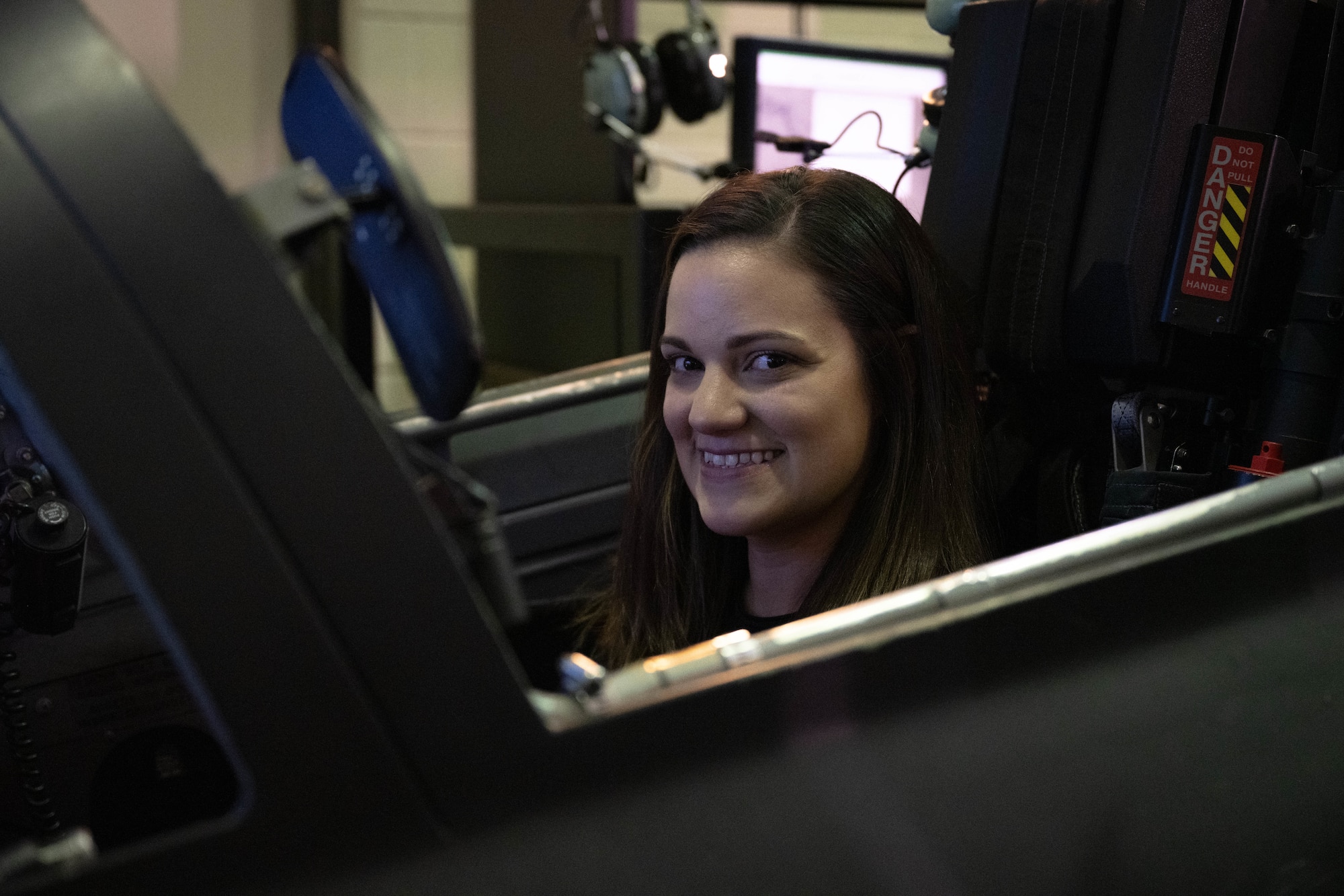 A military spouse poses while sitting inside a T-38C Talon simulator during Military Spouse Appreciation Day at Laughlin Air Force Base, Texas, May 8, 2026. Military spouses and family members experienced T-6A Texan II and T-38 simulators to learn more about Undergraduate Pilot Training. (U.S. Air Force photo by Airman 1st Class Darryl Keith)