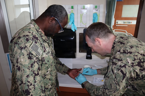 Lt. Cmdr. Jeff Hebert, laboratory department head at Naval Medical Center San Diego, prepares to demonstrate typing the blood of Lt. Gildas Noumen, laboratory department head for Naval Hospital Camp Pendleton, during the practical application phase of walking blood bank training on May 12, 2026, aboard Naval Hospital Camp Pendleton. Herbert served as the lead trainer during the two-day evolution that included both classroom instruction and practical application. "For a lot of these people, this is the first time they’ve had the opportunity to attempt phlebotomy for blood collection," Hebert said. “The more they can practice here, the more prepared they are when they go forward.”
