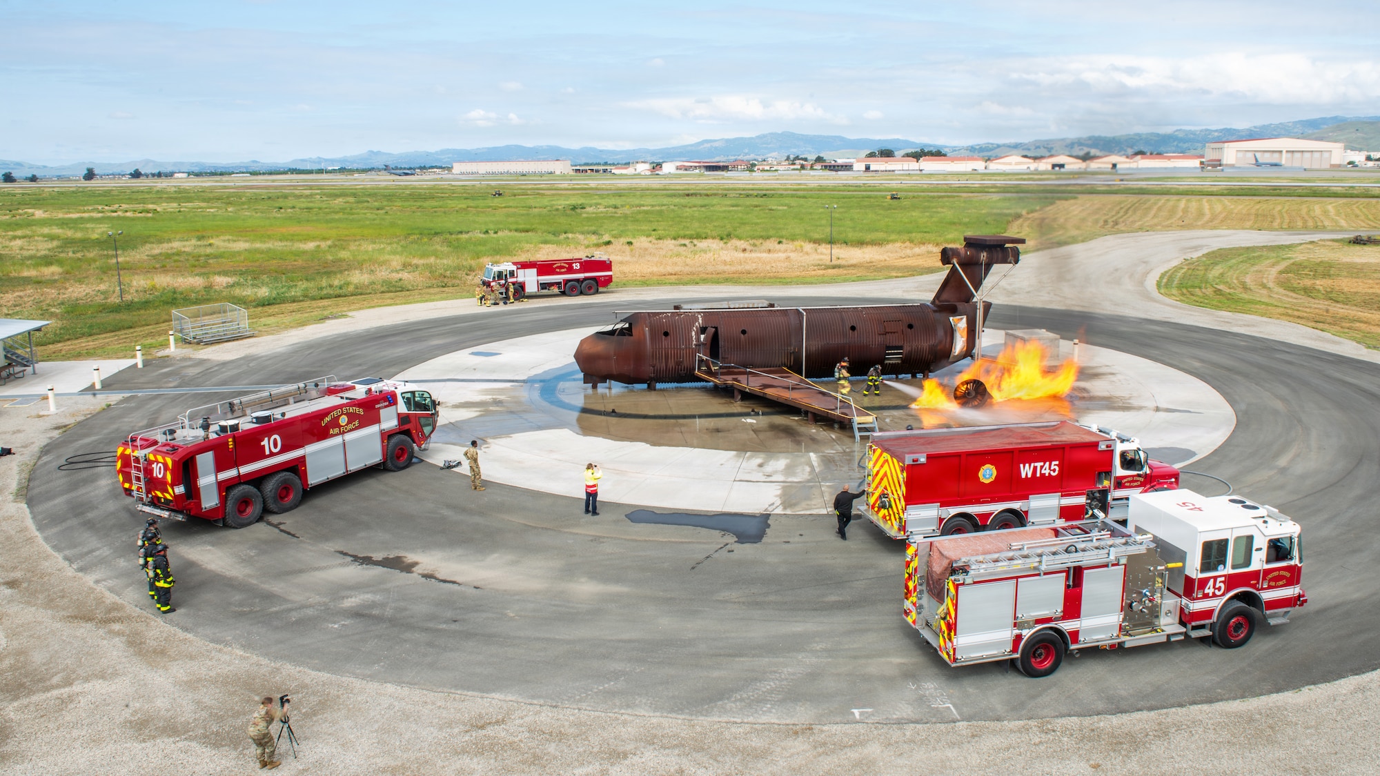 An overall for high atop a building of firefighters combating a simulated aircraft fire