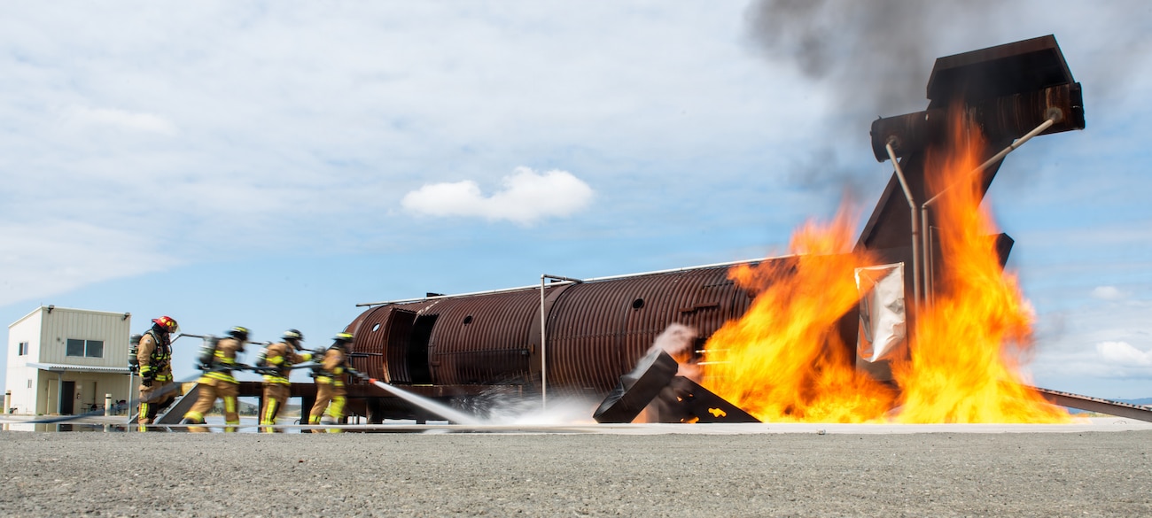 Firefighters combat a simulated aircraft fire