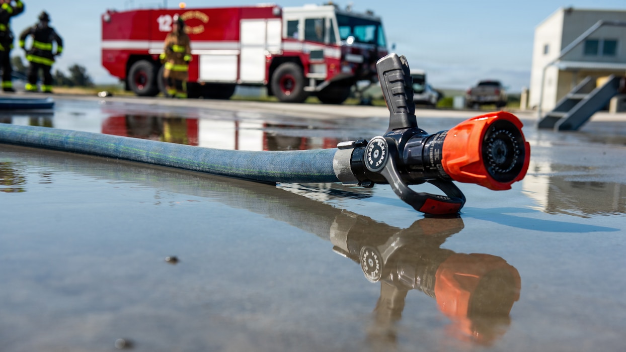 A hose line laying on the ground reflecting in the water